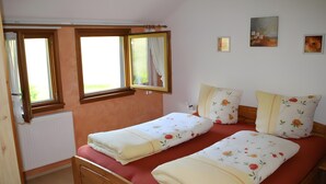 A bedroom with two beds, a window, a radiator, and a wall with a painting. - Gästehaus Weilerhof – Very Quiet and Sunny Location (Todtnauberg)