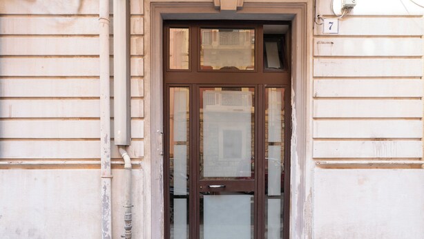 A double door with glass panels, a number '7' above it, and a small window above the door. - Meta Apartment by Wonderful Italy  (Bari)