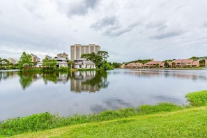 A calm lake with buildings in the background.