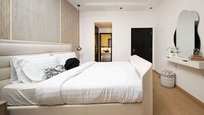 A modern bedroom with a large bed, a bedside table, a mirror, and a small stool. - Dubai Marina Apt w/ Pool, Gym & Balcony Views (Dubai)