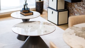 A modern interior with round tables and a brick wall. - Dubai Marina Apt w/ Pool, Gym & Balcony Views (Dubai)