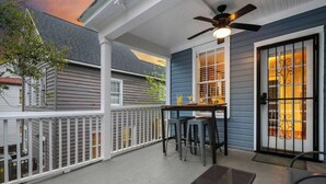 A covered porch with a table and chairs, a ceiling fan, and a door with a window. - Spacious 3BR Home, Walk to King St! (Charleston)