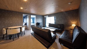 A modern living room with a wooden ceiling, a sofa, a coffee table, and a dining area with chairs.