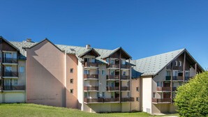 A multi-story residential building with balconies and a flat roof.