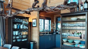 A wooden interior with a dining table, chairs, a chandelier made of branches, and a kitchen area with cabinets and shelves. - Ready for renovation! | 4-minute walk to the ski lift | 10-minute walk to the wellness center/spa (Les Collons 1800m)