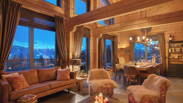 A cozy living room with a sofa, armchair, and coffee table, featuring a mountain view through large windows. - Ready for renovation! | 4-minute walk to the ski lift | 10-minute walk to the wellness center/spa (Les Collons 1800m)