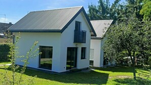 A modern two-story house with a sloped roof, large windows, and a well-maintained lawn. - New, Comfortable Holiday Home by the sea (gmina Karnice)