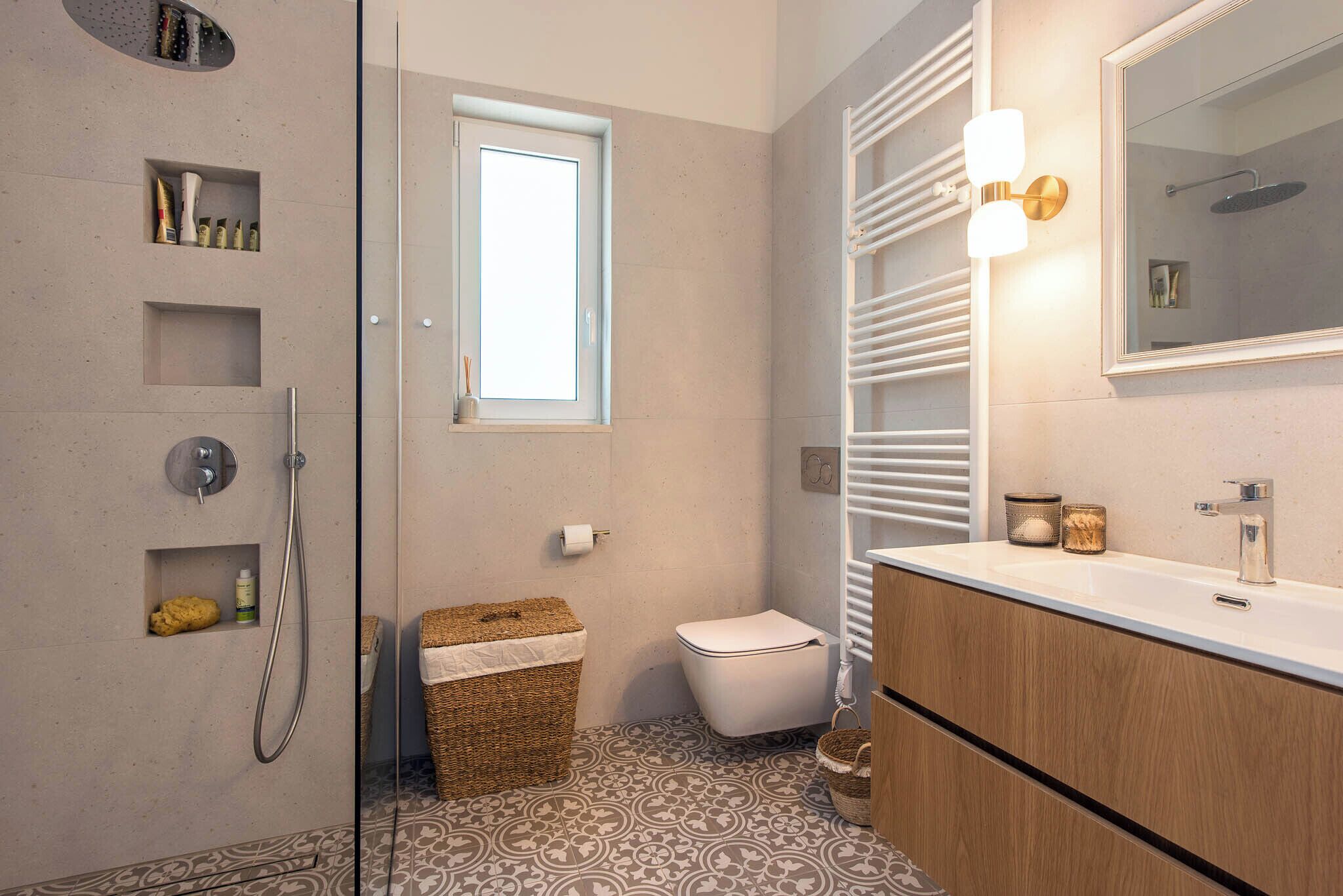 A bathroom with a shower, toilet, and vanity with a mirror.