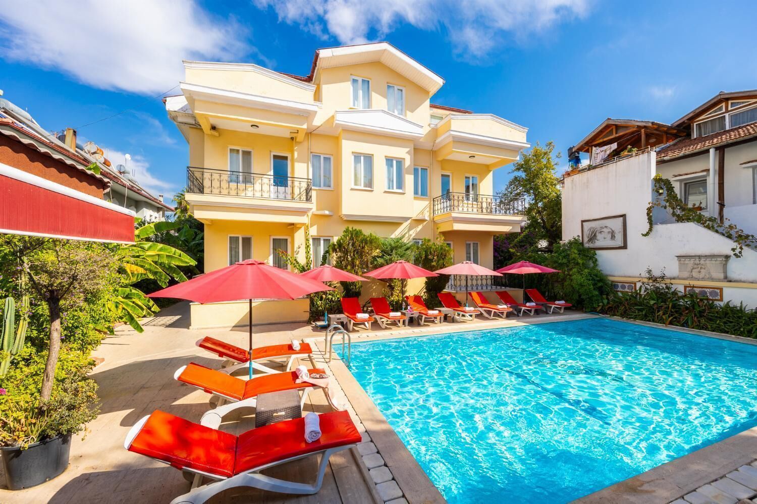 Un hotel con piscina, tumbonas y sombrillas.