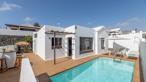 A modern pool area with a clear pool, a pergola, and outdoor seating. - Vacation Home 'Timanfaya' with Sea View, Private Pool and Wi-Fi (Tías)