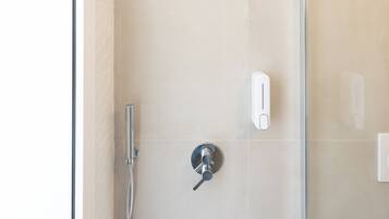 A modern shower with a handheld showerhead and a wall-mounted control panel.