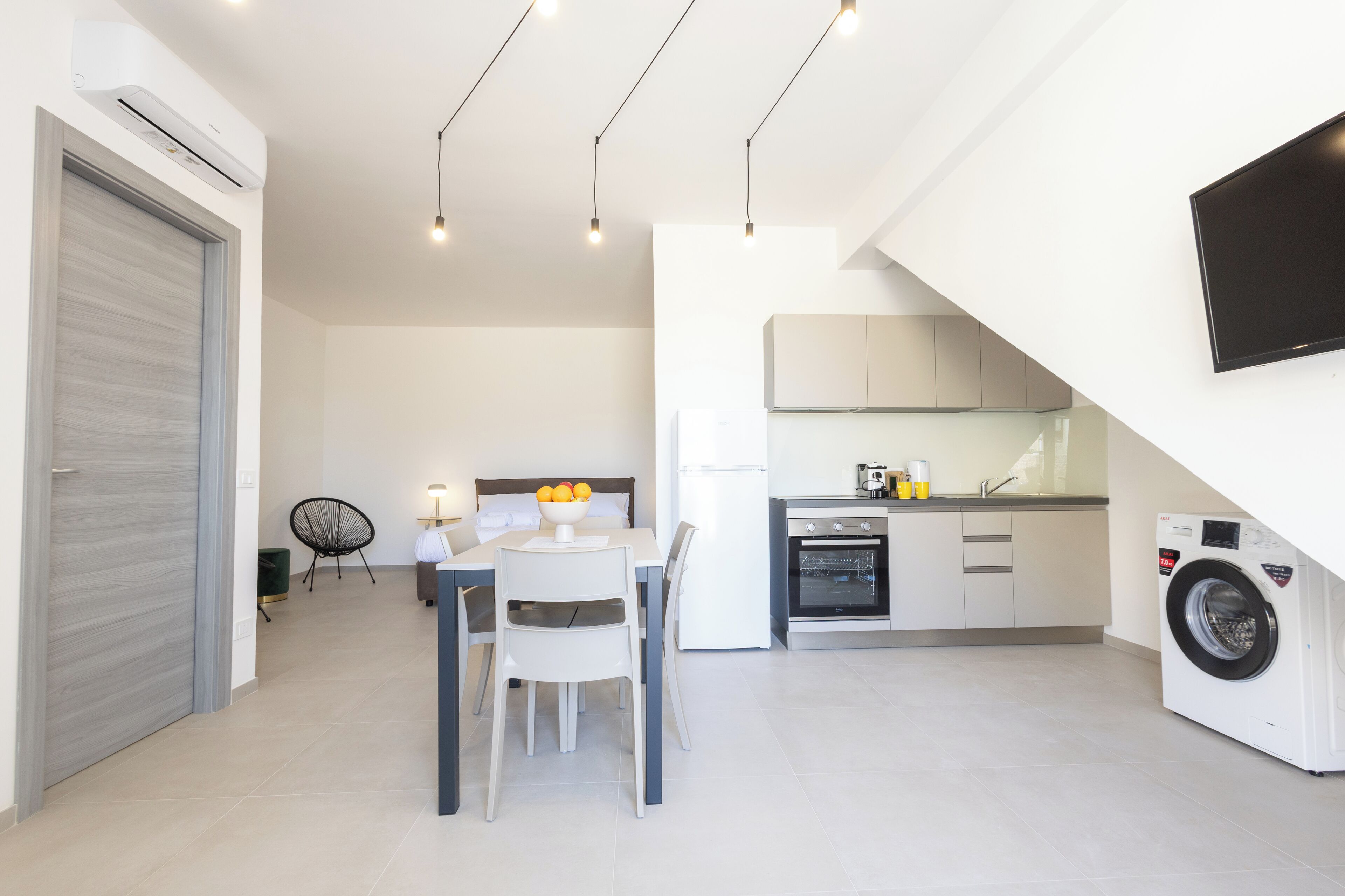 A modern kitchen with a dining area, built-in appliances, and a washing machine.