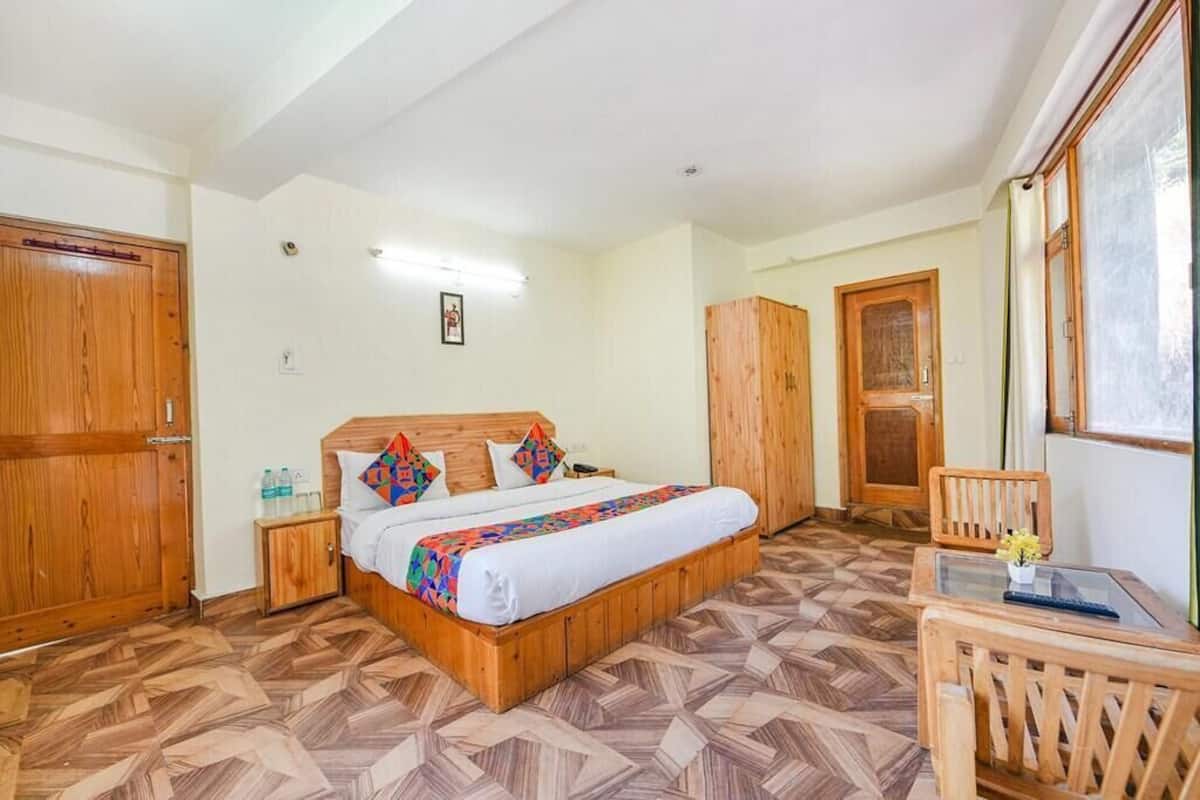 A bedroom with a wooden bed, a small table, and a chair.
