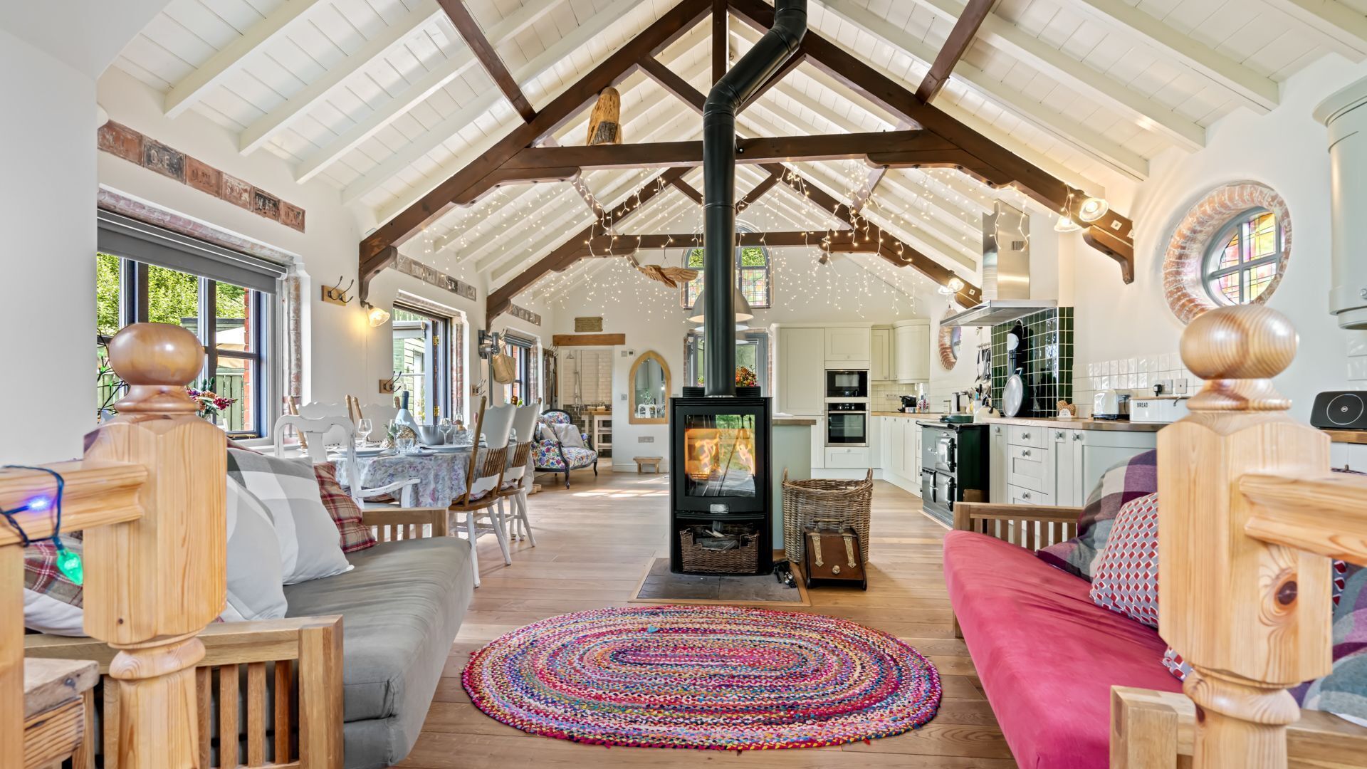 A spacious living area with a high ceiling, a fireplace, and a dining area with natural light.