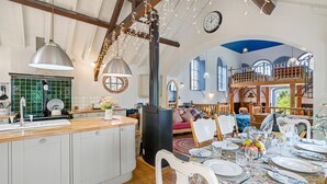 A spacious kitchen with a central island, wooden beams, and a rustic stove. - The Zion Chapel, Cinderford - sleeps 4 guests  in 1 bedroom (Soudley, Forest of Dean)