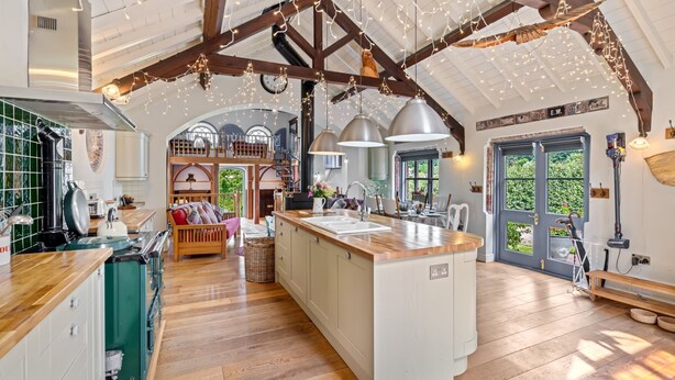 A spacious kitchen with a central island, wooden beams, and pendant lighting. - The Zion Chapel, Cinderford - sleeps 4 guests  in 1 bedroom (Soudley, Forest of Dean)