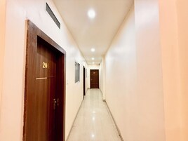 A corridor with wooden doors, numbered 201 and 202, leading to rooms.