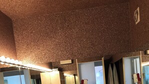 Un bagno con un grande specchio, una vasca da bagno e un lavandino. Sono presenti articoli da toilette sul mobile e un portascope.