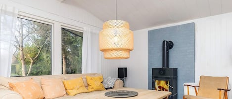 Una sala de estar acogedora con un sofá, una mesa de madera, una silla y una chimenea.
