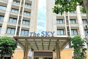 L’entrée d’un hôtel, avec une enseigne indiquant « The SKY » et un espace d’entrée abrité.