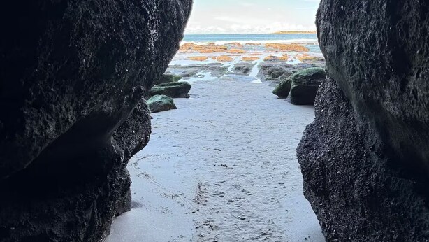 A natural rock formation with a clear view of the beach and ocean beyond. - Caves Beach, Sea Breeze - 5 min walk to the patrolled beach and caves (Caves Beach)