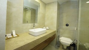 A modern bathroom with a large mirror, a sink, and a shower area. - Hotel Om Tower & Revolving Restaurant  (Jaipur)