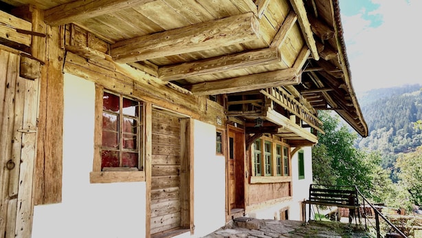 Un bâtiment en bois avec un chemin de pierre menant à un escalier en bois.