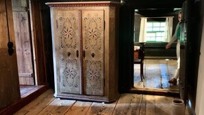Une pièce avec un lit, une armoire et un plancher en bois.