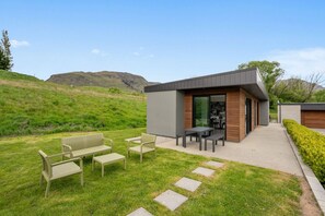 A modern house with a patio area featuring outdoor furniture. - Luxury Coronet Residence (Queenstown)
