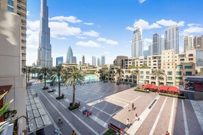 A spacious plaza with palm trees, benches, and a clear view of the surrounding high-rise buildings.