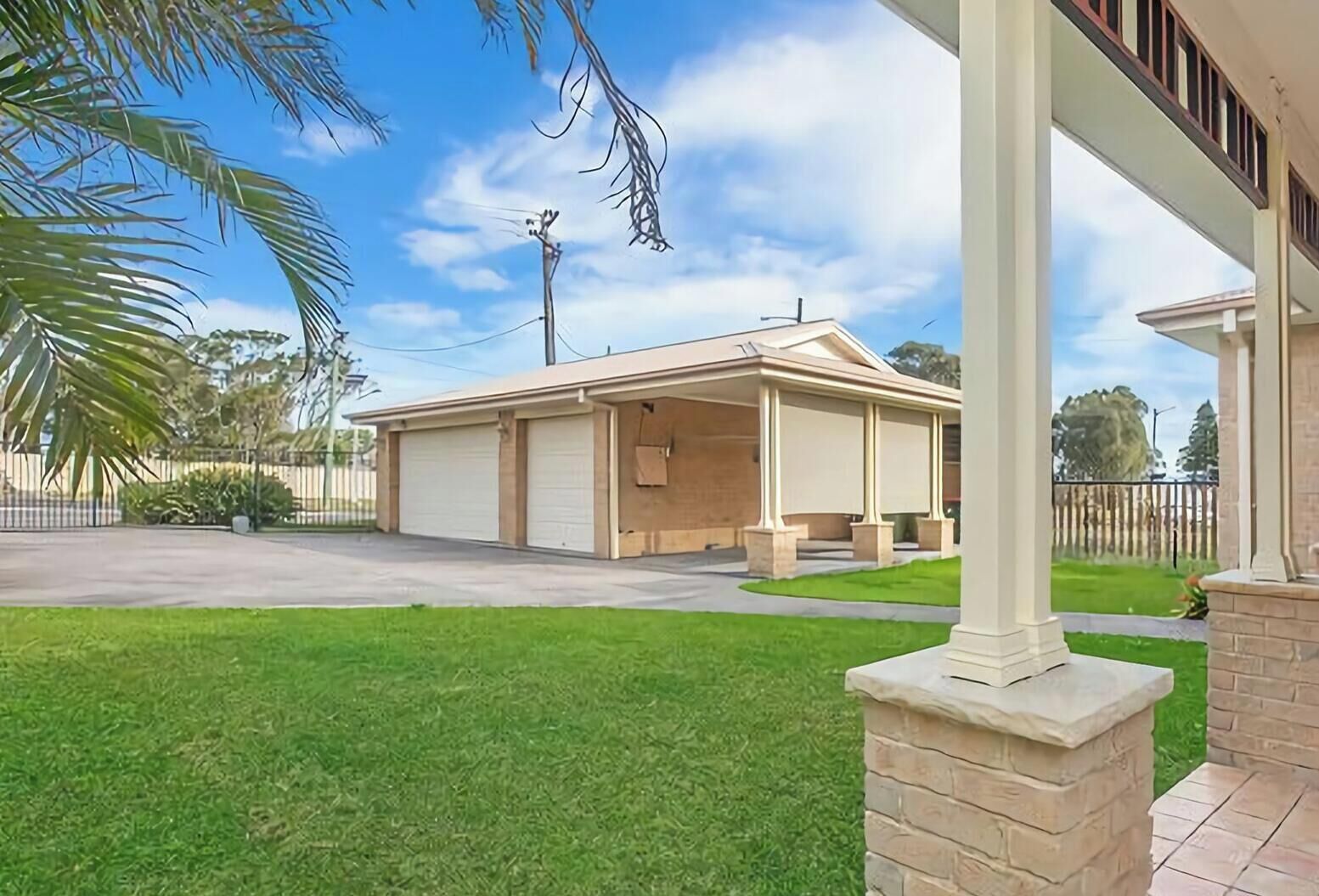 A two-story house with a covered porch, a garage, and a well-maintained lawn.