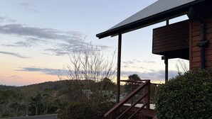 A building with a wooden staircase leading to a covered porch. - Havenwood Chalet 2 Bedrooms (Ravensbourne)