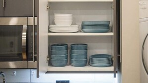 A kitchen with open cabinets displaying bowls, plates, and bowls. - Cozy 1BD In The Heart Of Rittenhouse Square (Philadelphia)