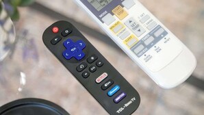 A black remote control with a blue OK button and a white remote control with a digital display and various buttons. - Cozy 1BD In The Heart Of Rittenhouse Square (Philadelphia)