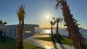 A modern house with a pathway leading to the sea, palm trees, and a clear view of the ocean. - Solemar Sicilia - Villa Gloria (Ficarazzi)