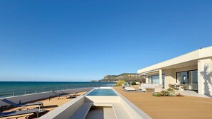 A modern outdoor pool area with lounge chairs and a view of the sea. - Solemar Sicilia - Villa Gloria (Ficarazzi)