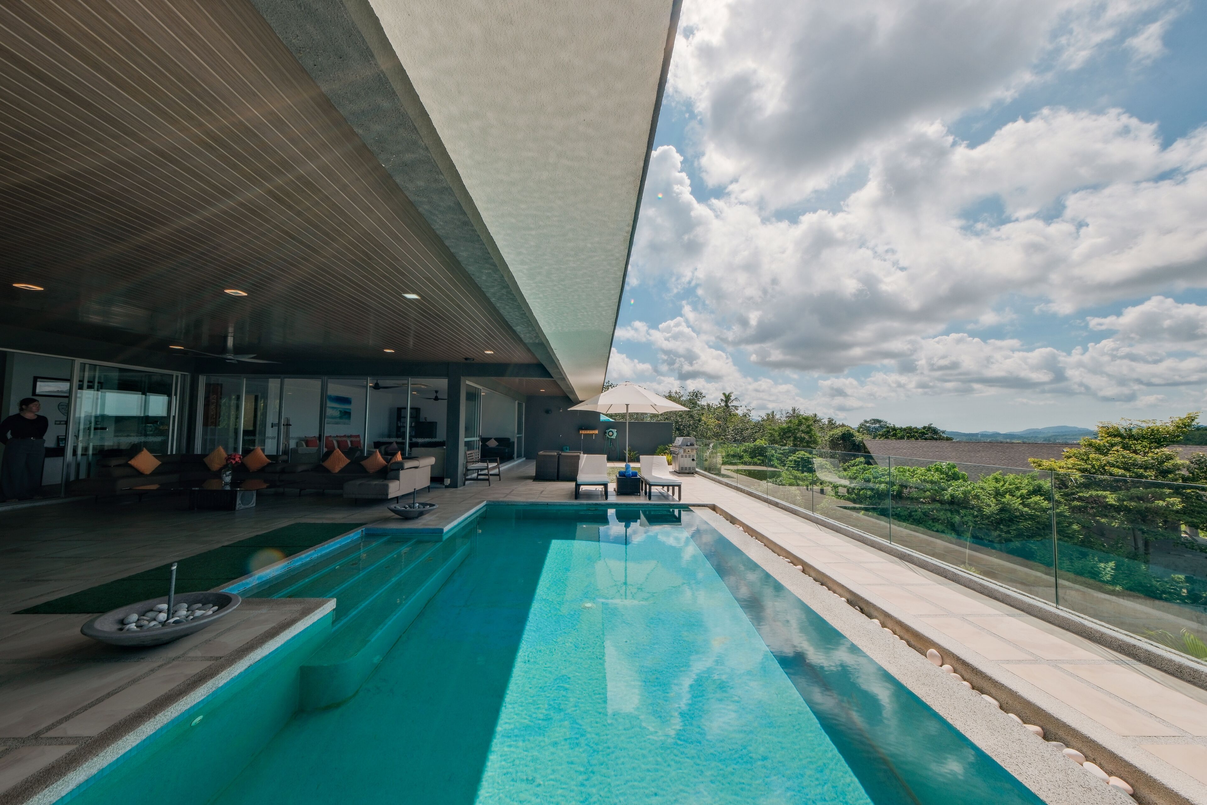 Un espace piscine moderne offrant une vue dégagée sur le ciel et le paysage environnant.