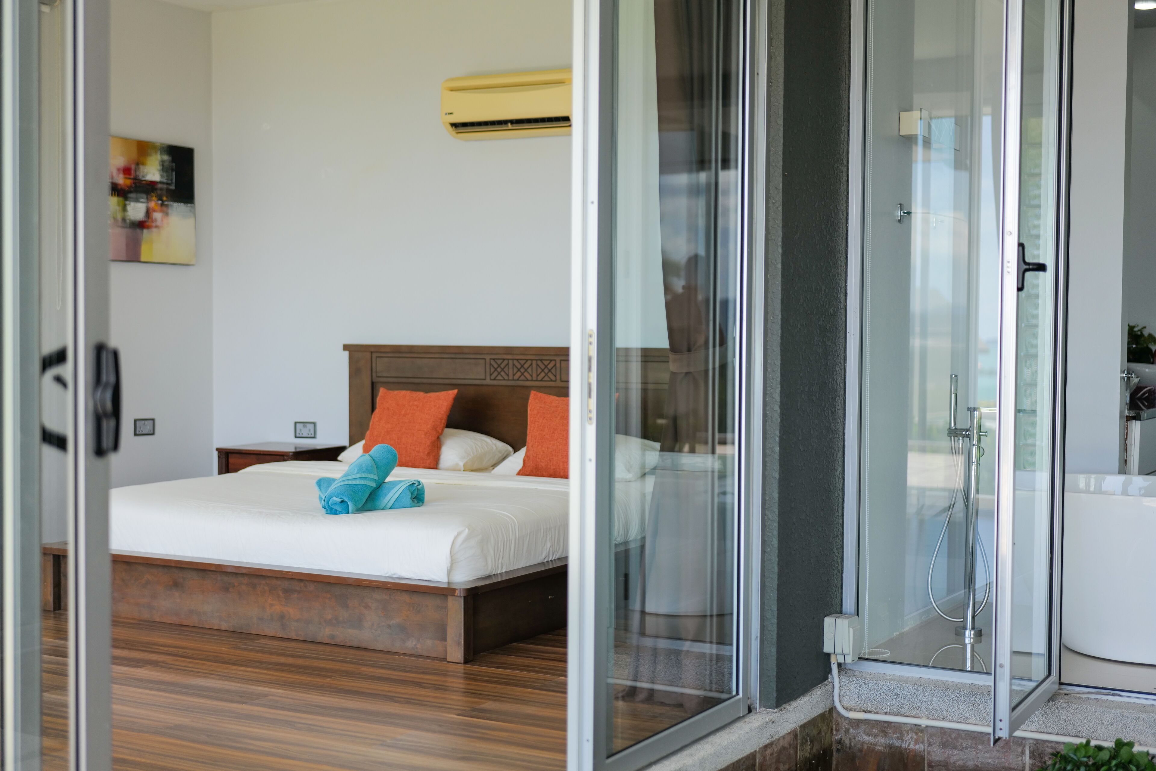 Une chambre d’hôtel équipée d’un lit, d’une douche et d’un climatiseur fixé au mur.