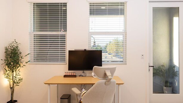 A modern office space with a desk, chair, computer, and two windows with blinds. - Near ONT Modern Designer Stay Bright Chic Spacious (Ontario)