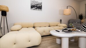 A modern living room with a sectional sofa, a round coffee table, and a floor lamp. - Near ONT Modern Designer Stay Bright Chic Spacious (Ontario)