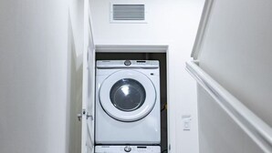 A staircase leading to a laundry room with two stacked washing machines. - Near ONT Modern Designer Stay Bright Chic Spacious (Ontario)