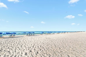 A beach with rows of blue umbrellas and lounge chairs. - Lazy River | 15th Floor Views | Beachfront Condo (Orange Beach)