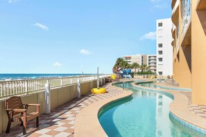 A pool area with a checkered floor, a bench, and a lifeguard stand.
