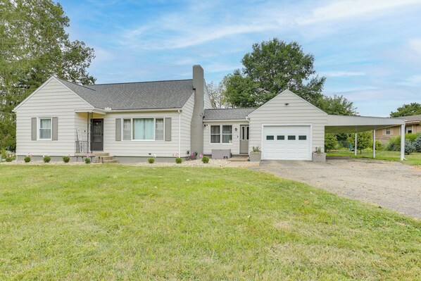 A single-story house with a garage, a covered porch, and a well-maintained lawn.