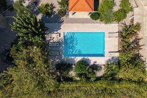 An aerial view of a swimming pool surrounded by lush greenery and a tiled roof structure. - Holiday Home With Pool Near Makarsk (Proložac)