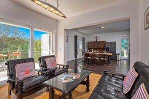 A spacious living area with a glass coffee table, leather sofas, and a dining area with wooden chairs. - Holiday Home With Pool Near Makarsk (Proložac)
