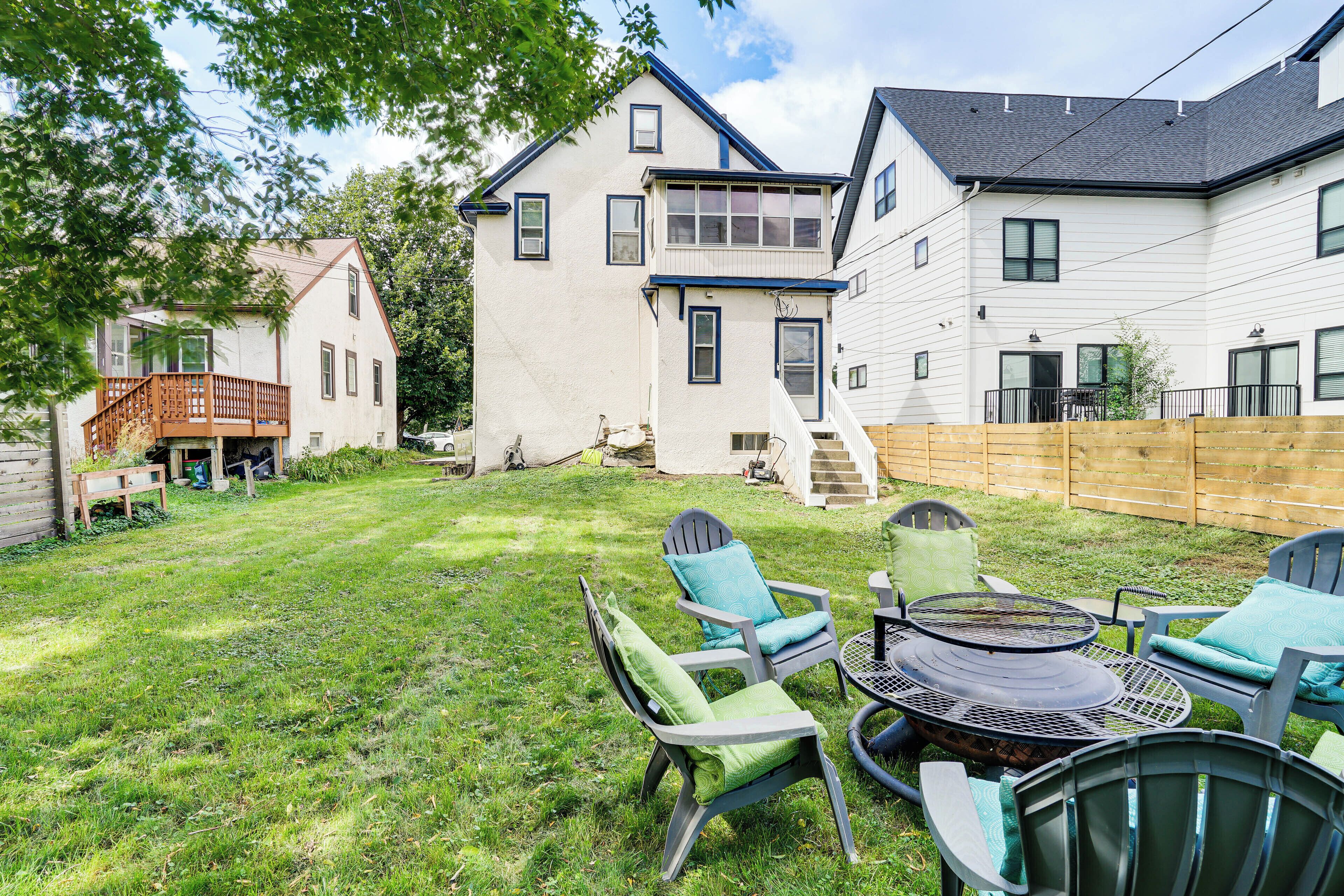 Un jardin avec un foyer extérieur, du mobilier de jardin et une terrasse en bois.