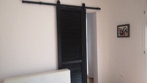 A room with a white sofa, a black sliding door, and a framed abstract artwork on the wall. - MyDream apartment No.2 (Dramalj)