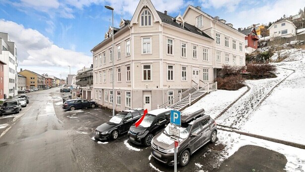 A multi-story building with a parking area in front. - Central Narvik Apartment, Walk to Train & Bus (Narvik)