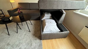 Une petite pièce comprenant un lit, un bureau, une chaise et une lampe.